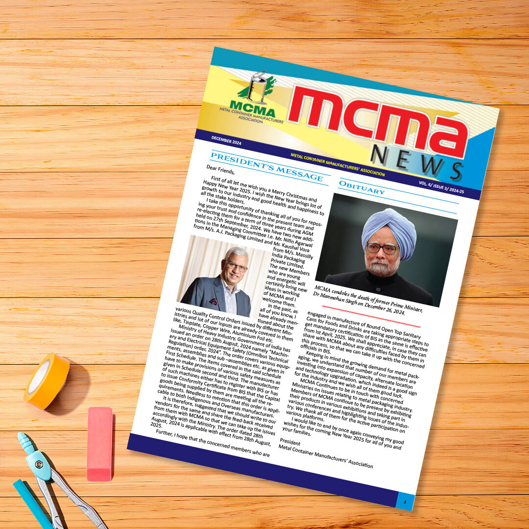Colorful MCMA News magazine on a wooden desk with nearby office supplies.