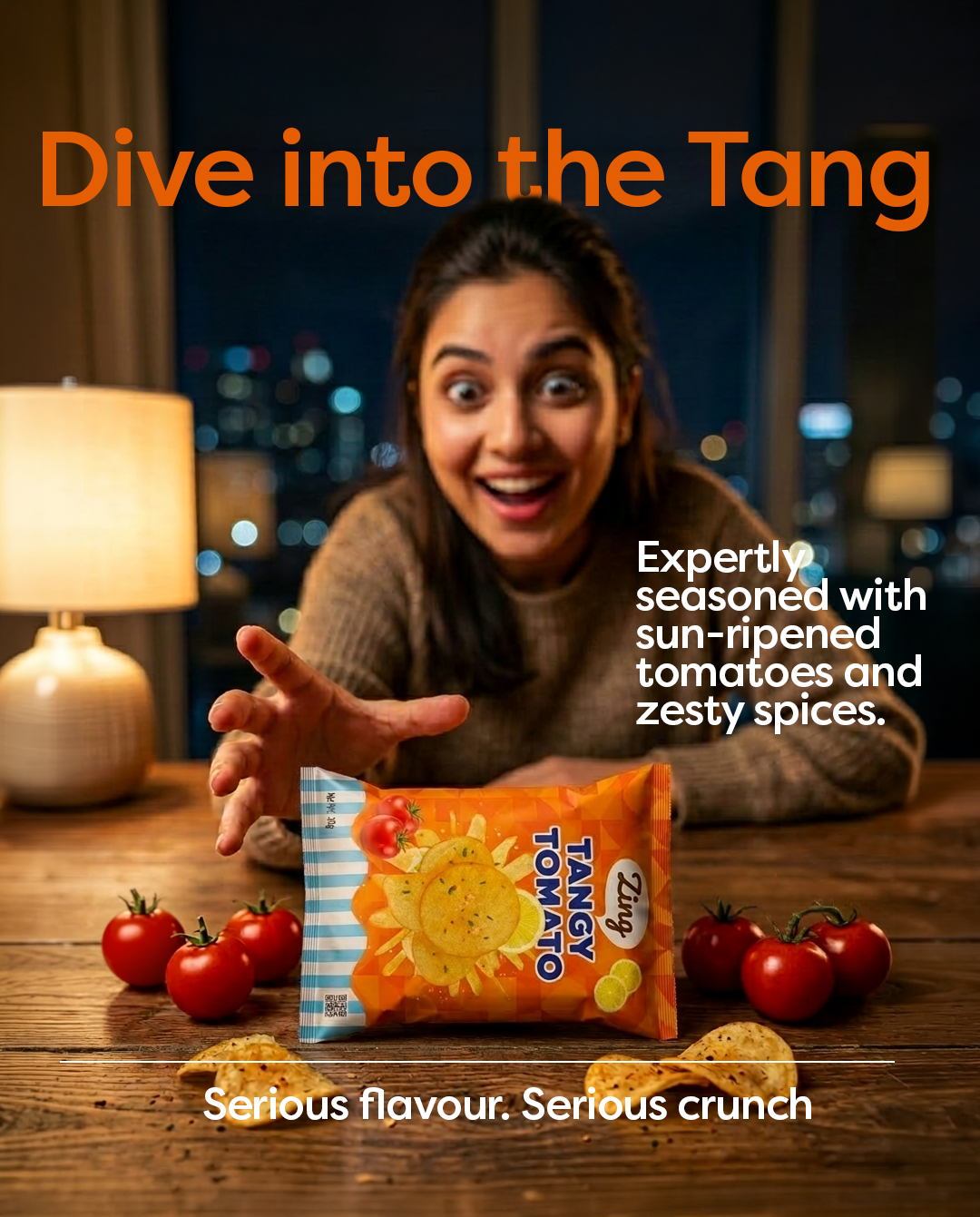 Smiling woman reaches toward a bag of Tangy Tomato chips on a wooden table with tomatoes around, bold ad text 'Dive into the Tang' above.